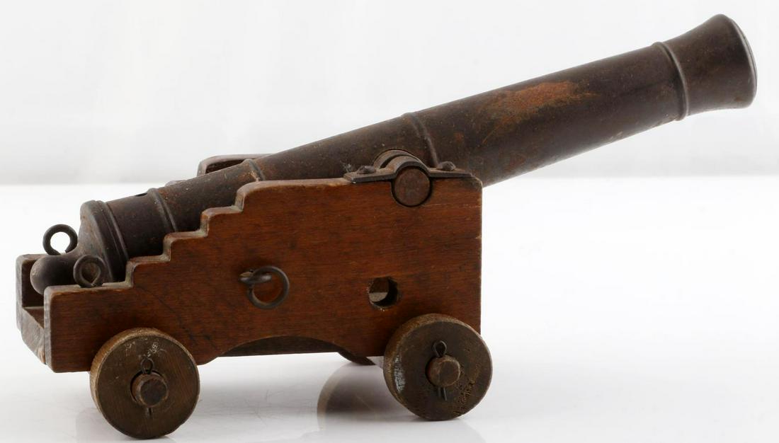 ANTIQUE IRON 7 1/2 INCH FIREABLE MINIATURE CANNON: Antique iron miniature fireable cannon. Measures 7 1/2 inches & 7mm bore. Missing a wheel on carriage.