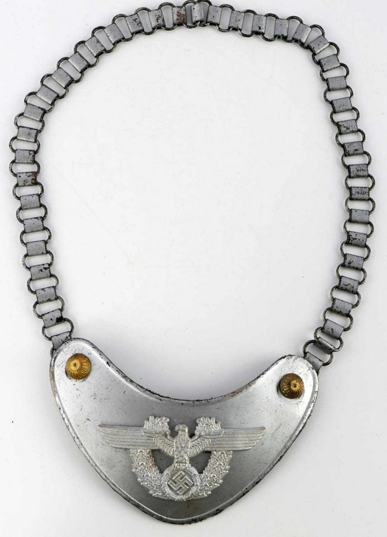 WWII GERMAN THIRD REICH POLICE GORGET: Police insignia on obverse. Felt backing with 3 hooks. One hook marked Assmann. Chain is magnetic and measures 24 inches. Gorget measures approx 6 3/4 inches. Very good condition. Unauthenticated, sol