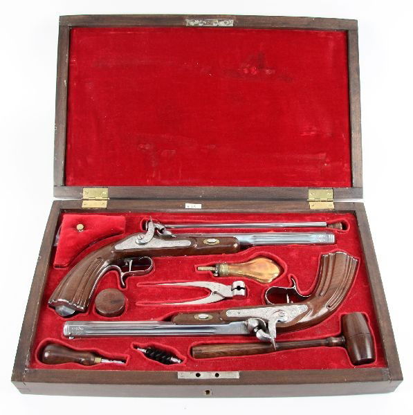 CASED PAIR OF REPRODUCTION DUELING PISTOLS: Pair of reproduction dueling pistols .44 caliber, percussion. Both made in Spain. Pistols are unfired in excellent condition, complete with red velvet lined wood presentation box, tools, caps, and bal