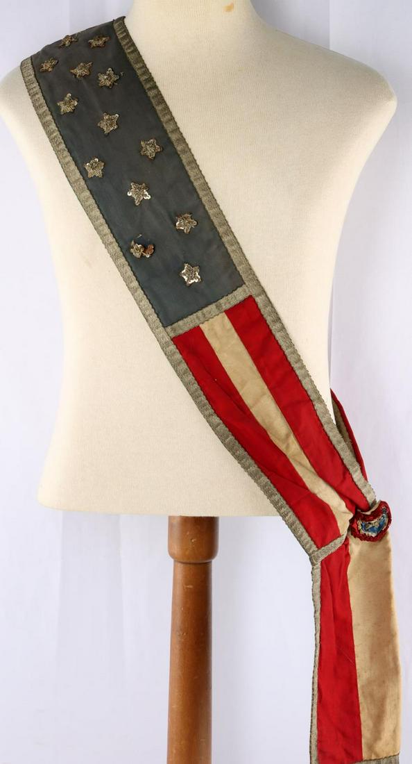 ANTIQUE 19TH CENTURY AMERICAN PARADE FLAG SASH: Patriotic parade sash featuring the stars and stripes of the American flag. 40 x 5 inches. Red and white stripes on one side and the opposite side bearing 13 sequin stars on a blue background. Stitche