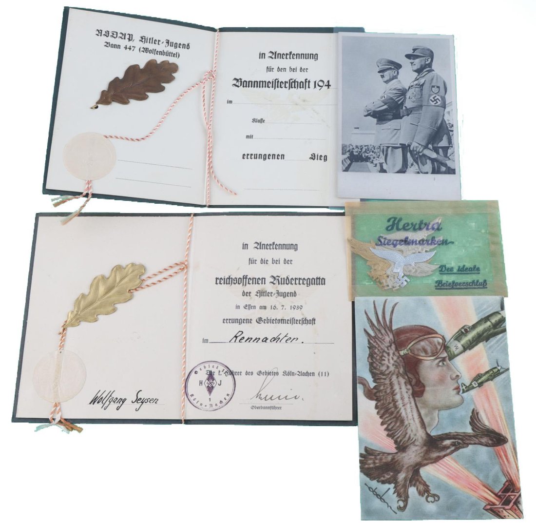 WWII GERMAN REICH HJ AWARD BOOKS HITLER POST CARD: Lot features 2 award booklets for Hitlerjugend, a Hitler postcard, and Luftwaffe postcard eagle stickers. Very good condition. Measurements range 1 7/8 - 6 inches.