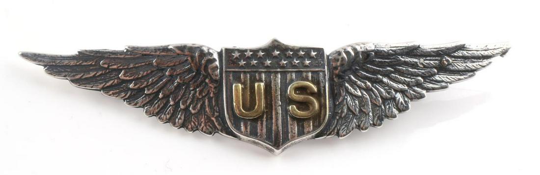 WWI US AVIATOR PILOT WING BADGE BY TIFFANY AND CO: US World War I Aviator Aero Pilot Wing by Tiffany. The dimensions are 2 7/8 X 5/8 inches tall.The front shows a shield with the letters ‘US’ in the center with 13 stars above. It is flanked by awi
