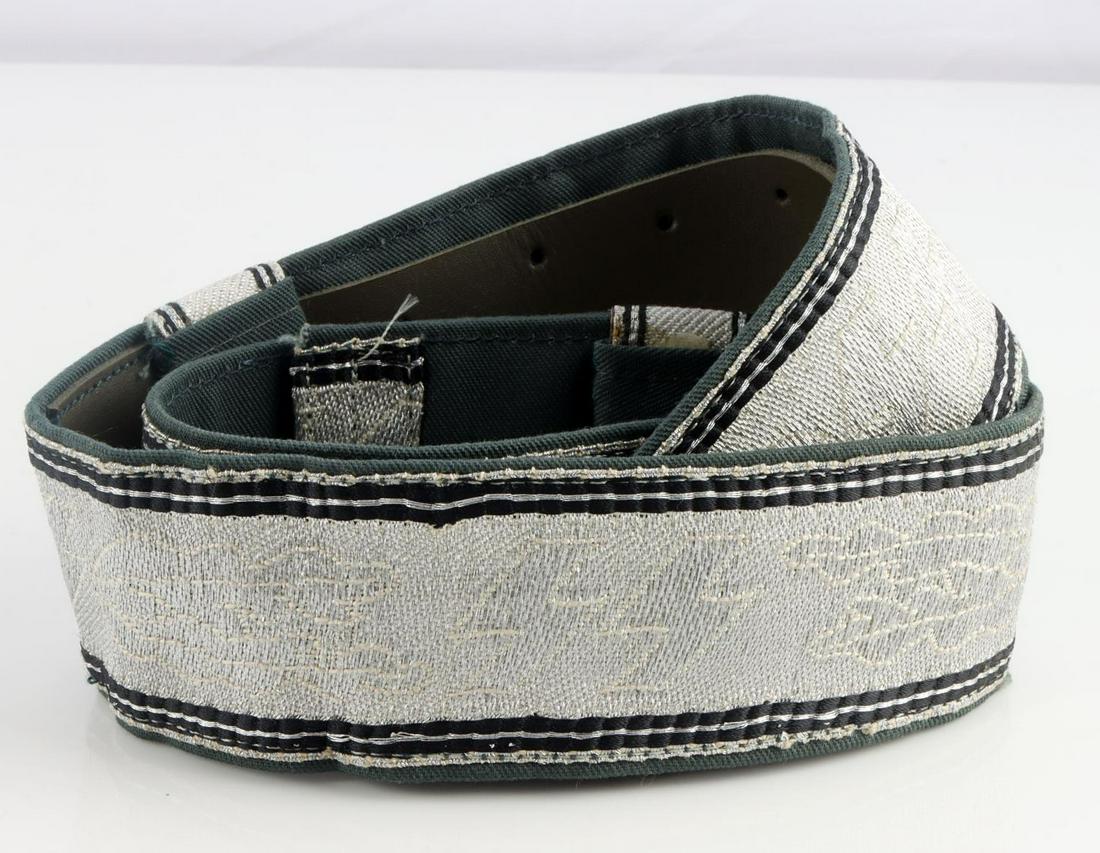 WWII GERMAN WAFFEN SS BROCADE OFFICERS BELT: German WWII Waffen SS Brocade Officers Belt. Measures 34 3/4 X 1 3/4 inches. Has rotating SS runes with oak leaves on the front. Flat silver bullion wire construction with a green cotton backing and a