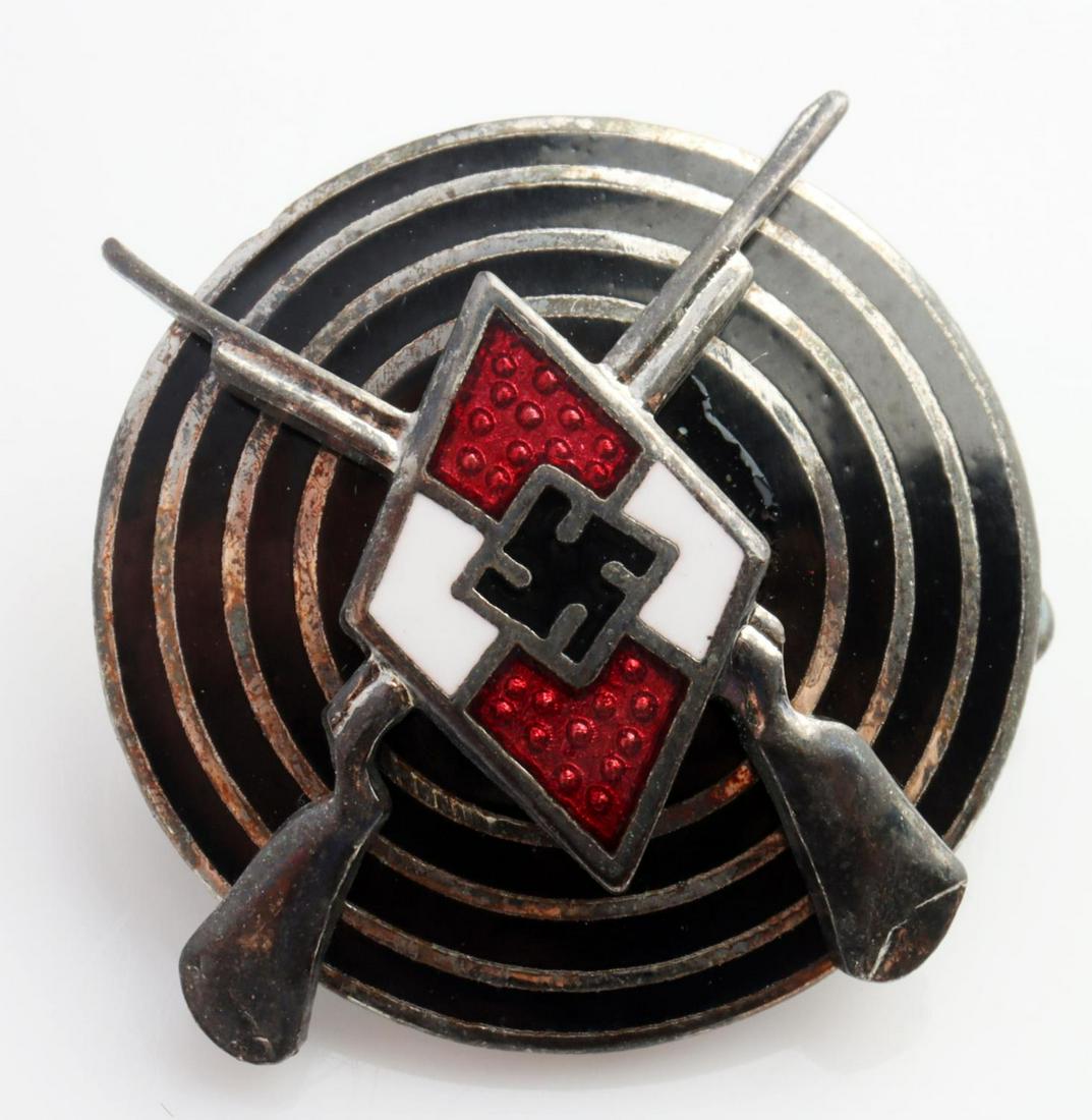 WWII GERMAN HJ SHOOTING MARKSMAN ENAMEL BADGE: German WWII Hitler Youth HJ Shooting Marksman Badge. Measures 13/16 inch diameter. The front shows a Hitler Youth diamond in the center with a pair of crossed rifles behind. There is a bull's eye in t
