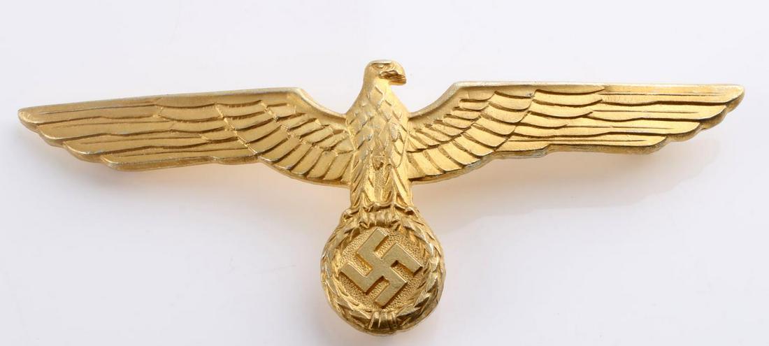 WWII GERMAN HEERSUMMER TUNIC BREAST EAGLE BADGE: German WWII Army General Summer Tunic Breast Eagle. Measures 3 3/4 X 1 7/16 inches. The front shows a Reichsadler. The reverse side is maker marked ‘A’ for the manufacturing firm of Assmann. Has a
