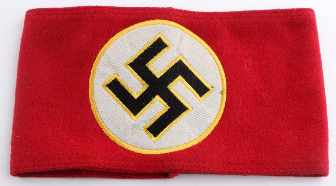 WWII GERMAN THIRD REICH POLITICAL LEADER ARMBAND: German WWII Political Leader Swastika Arm Band. Measures 8 3/8” wide by 4 3/4" inches tall Thefront shows a black swastika with a yellow border. It is machine sewn onto a round white circlethat is s