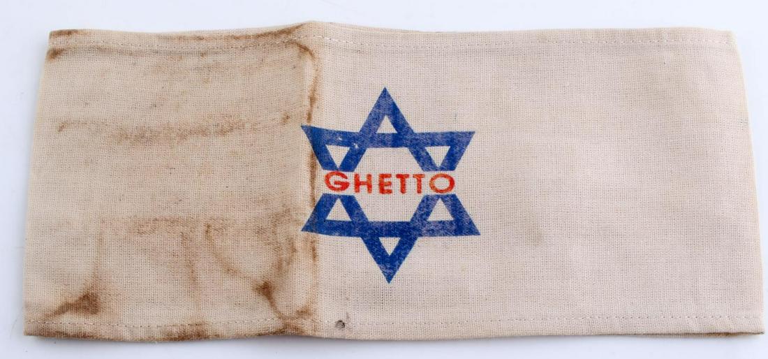 WWII GERMAN THIRD REICH CONCENTRATION CAMP ARMBAND: German WWII Concentration Camp GHETTO Arm Band. Measures 9” wide by 3 7/8” inches tall.The front reads ‘GHETTO’. There is a blue Jewish Star in the back ground. One piece machinesewn printed c