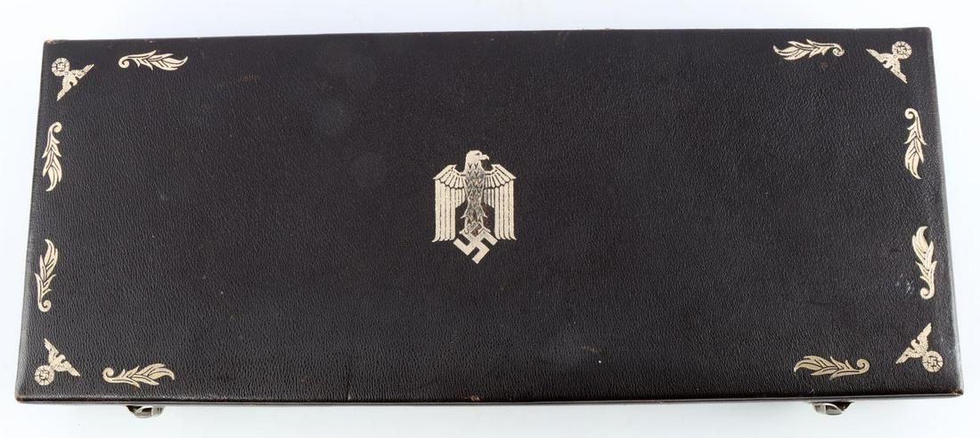 GERMAN HITLER YOUTH PRESENTATION DAGGER CASE: Dark brown German Hitler Youth leader leatherette presentation dagger case. Measures 16 5/16 inches long by 6 3/4 inches wide and 2 1/4 inches tall. The lid is stamped with an eagle clutching a swasti