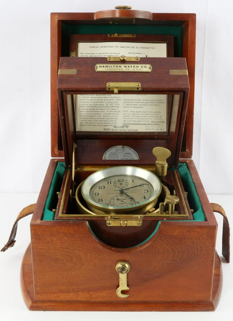 WWII 1941 HAMILTON 85 SHIP MARINE CHRONOMETER: Felt-lined display case sits inside another felt-lined storage/display case. Display case is 7 7/8 W x 7 7/8 D x 7 7/8 H, outer case is 12 3/4 W x 10 3/8 D x 9 3/8 H inches. Clock winds and holds time