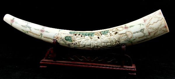 DECORATIVE CHINESE CARVED BONE: Chinese carved bone featuring three Buddhist monk figures. Colored decorative scrolls and floral patterns cover the remaining portion of the bone. 28 inches long and 4 inches wide at its thickest poin