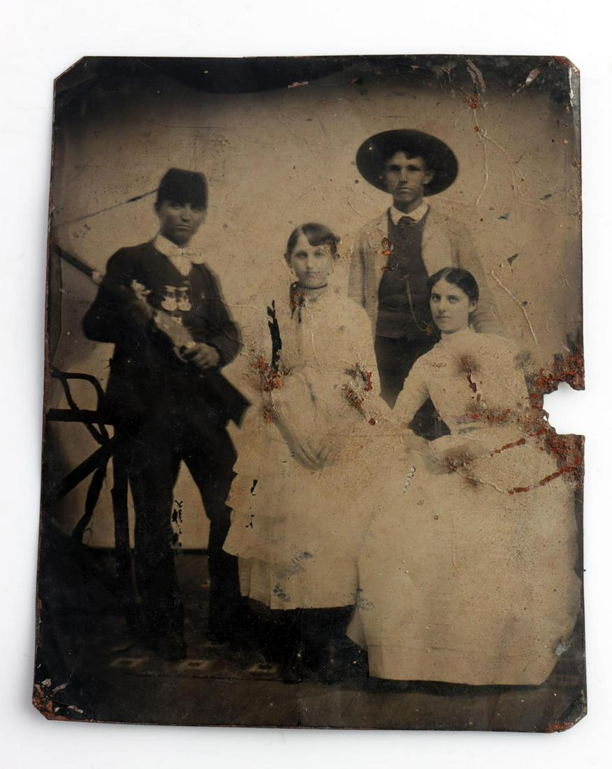 1/4 PLATE TINTYPE PHOTOGRAPH HOLDING LEVER ACTION: Tintype photo where man on the left is holding early lever action rifle, perhaps a Spencer and what appears to be GAR medals or shooting medals. Rust hole on right side, otherwise good condition.