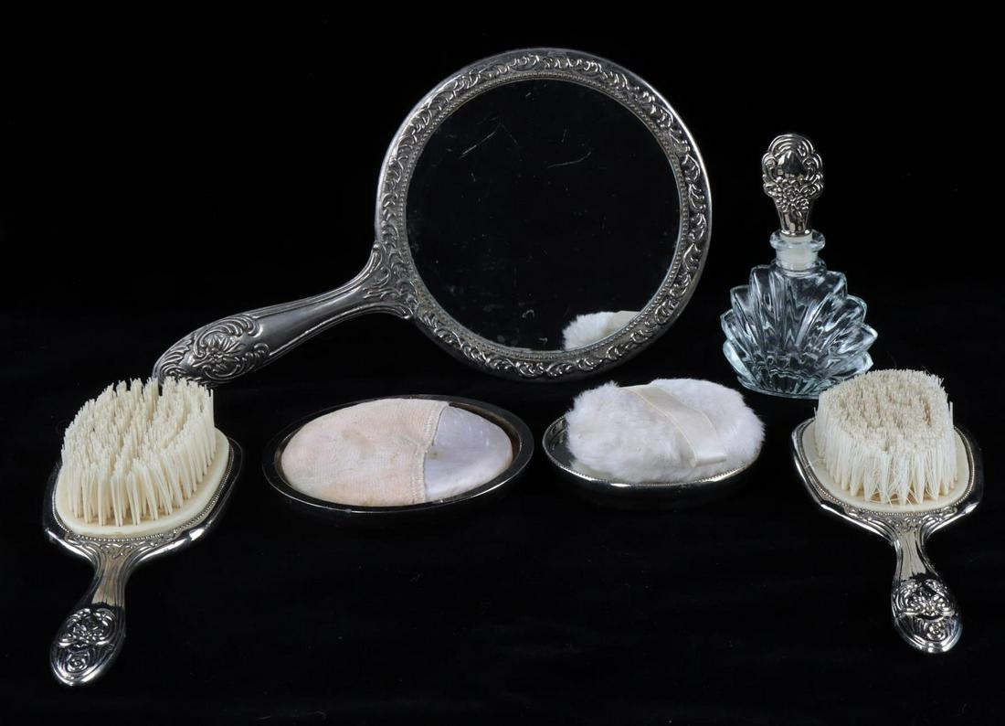 WWII GERMAN EVA BRAUN MONOGRAMMED VANITY SET: WWII German Eva Braun monogrammed vanity set. Includes hand mirror, two soft bristle brushes, glass perfume bottle with stopper, powder compact lid, small compact mirror, and two powder puffs. Pieces 