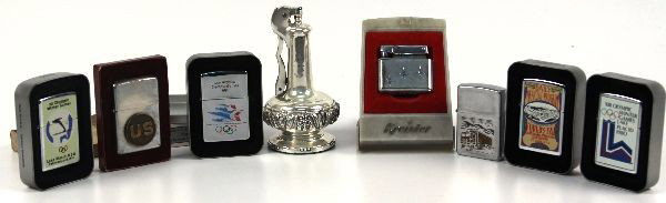 ZIPPO RONSON LIGHTER LOT ARMY OLYMPICS TRUCKER: A collection of lighters to include an early Zippo in its box with a U.S. Army disc affixed, some later issues all in box, 1984 Olympics, and 1980 Winter Games, Louisiana purchase commemorative, and a