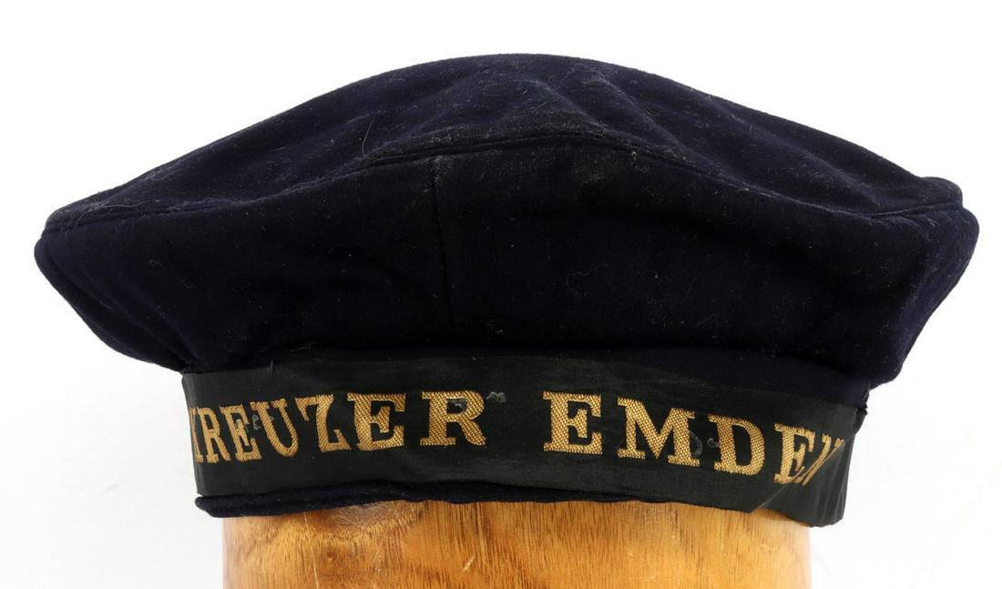 WWII GERMAN REICH KRIEGSMARINE KREUZER EMDEN CAP: Blue wool with black headband and gold letters "KREUZER EMDEN". Red cotton lining and leather headband with wear. Hermann Haine make. Medium sized cap. Very good condition. Non-fluorescing. This lot h