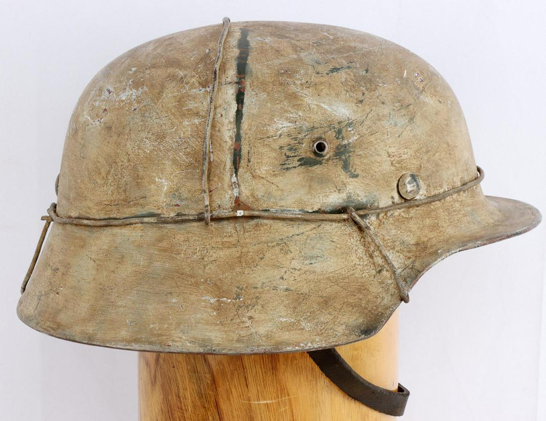 WWII GERMAN THIRD REICH M40 SNOW CAMO HELMET: Heat stamps are obscured, good liner and chin strap. Good genuine helmet and external appears period, some darkening perhaps done later internal to liner and helmet.
