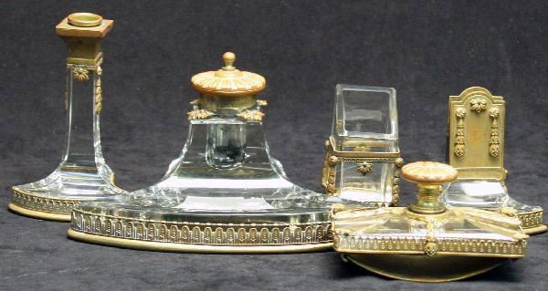 ANTIQUE FIVE PIECE CYRSTAL AND BRASS DESK SET: Five piece antique crystal and glass desk set including ink well, envelope holder, candleholder, pen holder, and a rocker blotter. Appears to be Napoleonic, features no makers mark. Slight glass chipp