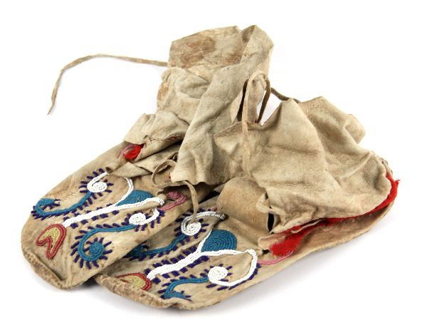 ANTIQUE NATIVE AMERICAN BEADED MOCCASINS: Beaded in a stylized fashion with green, white, blue, yellow, red, and pink beads. There is a felt band at the ankle and a 4 inch folding flap with no fringe. The "tongues" are approximately 6 inches
