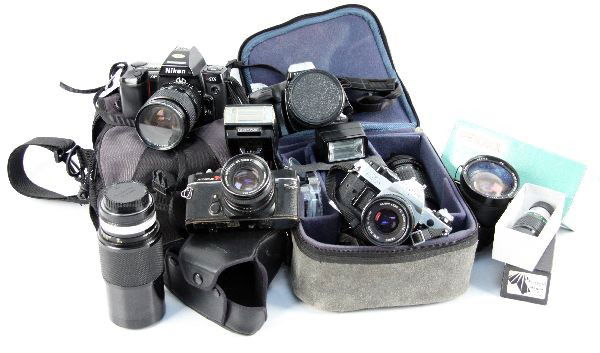 LARGE LOT OF CAMERAS, LENS AND OTHER EQUIPMENT: Lot of cameras and equipment including a Nikon N8008 with a Haze 62mm lens; a Konica Autoflex with Olympus flash and a 50 mm lens; a Minolta 300si with 77mm lens; a Cannon AE-1 with 50 mm lens, 75mm l