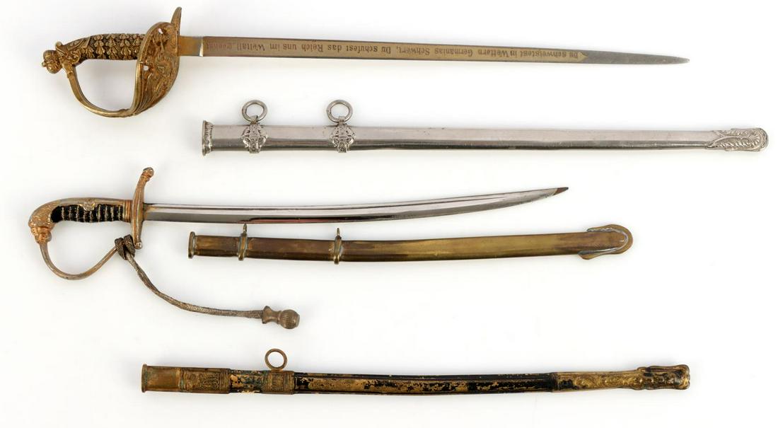 TWO MINIATURE GERMAN OFFICERS SWORDS WWI & WWII: Two miniature German officer's swords, one with a lion's head pommel. and a portapee. Other with inscription on both sides. Both have sheaths and comes with extra sheath for missing third sword.