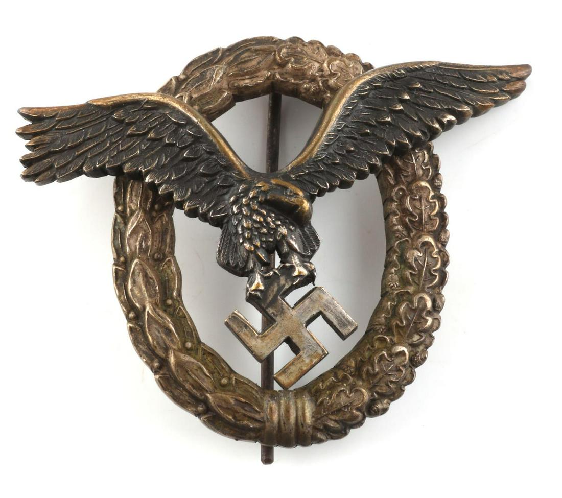 WWII GERMAN THIRD REICH LUFTWAFFE PILOTS BADGE: WWII German Luftwaffe Pilot's badge. Obverse features Luftwaffe eagle surrounded by an oak leaf wreath. Thin vertical 180 degree lie pin with 'c' catch. Reverse eagle marked "JMME". Two rivet construc