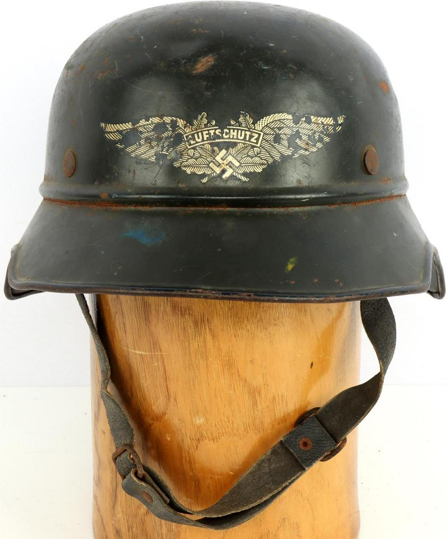 WWII GERMAN NAMED LUFTSCHUTZ M38 HELMET W LINER: WWII German Luftschutz M38 named helmet with liner. Forest green painted steel with the Luftschutz decal to the front. Rear interior skirt heat stamped "RL2 - 38/28" and painted Vertrieb genehmigt gem