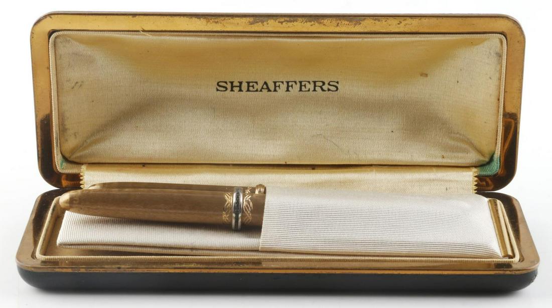 VINTAGE SHEAFFERS FOUNTAIN PEN AND PENCIL W CASE: Vintage Sheaffers fountain pen and pencil set with pocket holder and original case. Golden colored pen and pencil in very good condition. Black leather case with beige silk interior. Off-white silk po