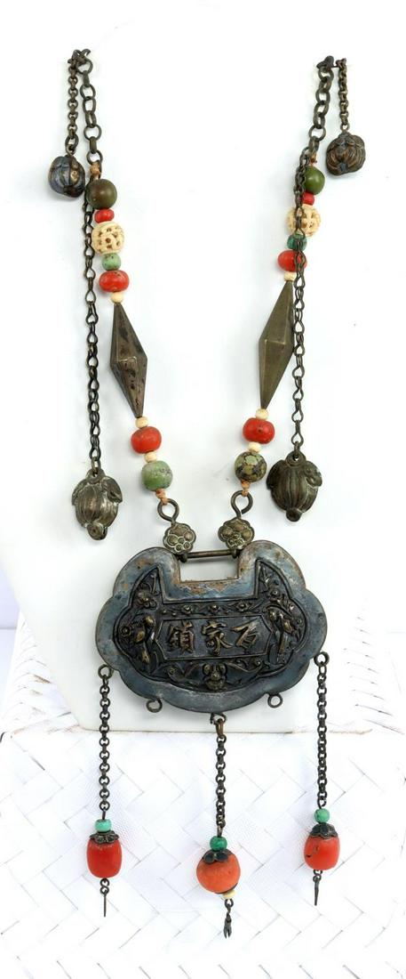 ANTIQUE CHINESE SILVER NECKLACE W CORAL & BONE: Chinese antique silver embossed lock pendant necklace with turquoise, brass, coral and bone beads. Length is 23-24 inches.