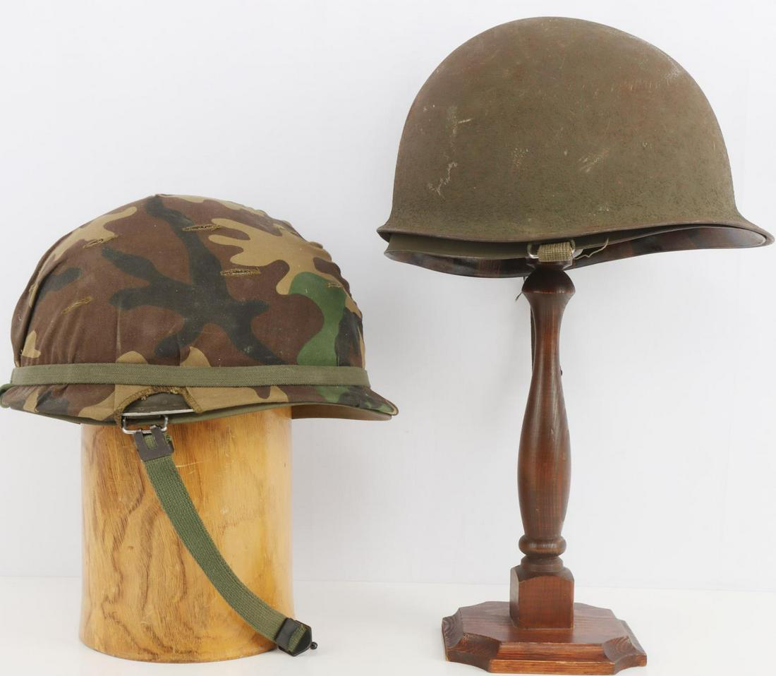 2 VIETNAM ERA US ARMY M1 COMBAT HELMETS W LINERS: 2 Vietnam Era Untied States Army M1 combat helmets with liners and one camo cover. Both olive green painted steel shells with rear seams. Heat stamp visible on the non-covered helmet "4601S." Camo cov