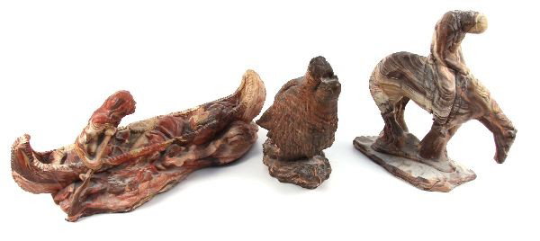 THREE STATUES MADE FROM MISSISSIPPI RIVER MUD: Three statues made from Mississippi River mud. Including a wolf measuring 10 by 7 by 5 inches, Indian in canoe measuring 19 by 6 by 8 inches, and End of the trail measuring 12 by 6 by 12 inches.