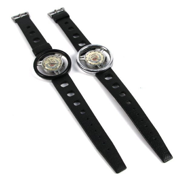 TWO CADILLAC STEERING WHEEL SPORT WATCHES: Two vintage Cadillac steering wheel sport watches. Black stainless steel, water proof, 18mm tropic. Swiss made. Base metal bezel. In good condition.
