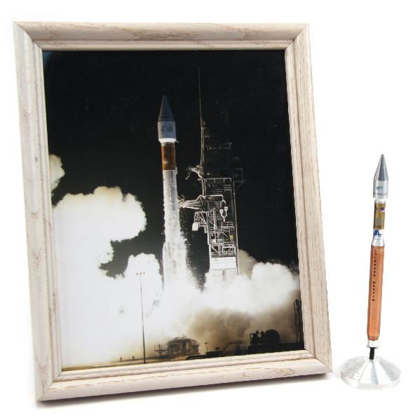 HOT BIRD 6 VANGUARD ROCKET LAUNCH MODEL: Lockheed Martin "Hot Bird VI" Vanguard Atlas V Inaugural Launch rocket presentation model in aluminum, standing 7.5 inches with framed photo of launch.