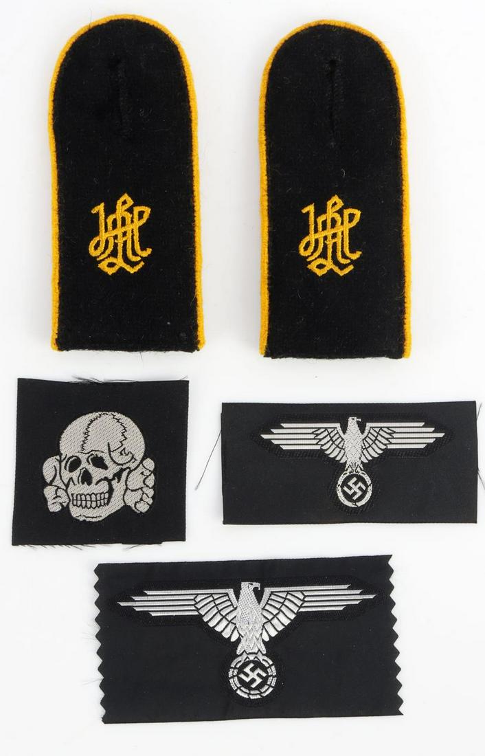 WWII GERMAN WAFFEN SS PATCH SHOULDER BOARD LOT: German WWII Waffen SS Cloth EM Insignia Grouping. Includes a Waffen SS arm eagle; Totenkopf SS cap skull; SS cap eagle clutching a swastika in his talons. Plus a pair of Waffen SS LAH Leibstandarte Ad