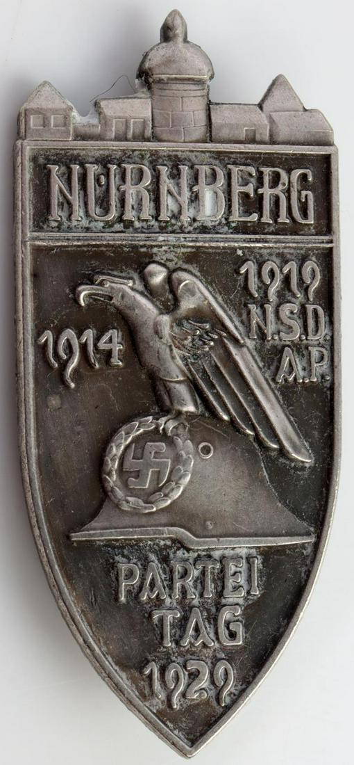 WWII NSDAP NURNBERG PARTEITAG 1929 BADGE: Measures 7/8 X 1 7/8 inches. The front shows an eagle standing top of a German Helmet. Reads Nurnberg 1914 - 1919 NSDAP Parteitag 1929. Has thin vertical safety pin back. Unauthenticated, sold as is.