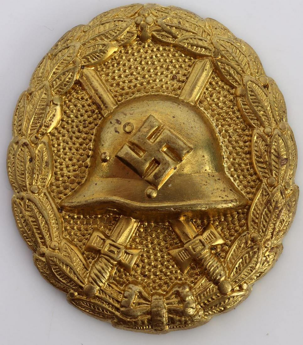 WWII GERMAN REICH SPANISH GOLD CONDOR WOUND BADGE: Front shows German helmet in center with crossed swords behind. Oak leaf wreath. Pin not present. Die struck. Measures 2 inches. Very good condition. Unauthenticated, sold as is.