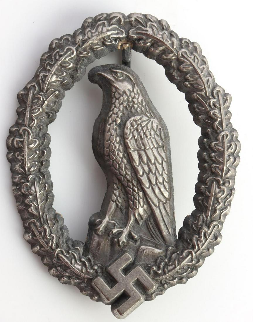 WWII GERMAN REICH RETIRED PILOT BADGE: German WWII Luftwaffe Retired Pilot Badge. Measures 1 15/16 X 2 1/2 inches The frontshows an eagle standing on a rock. Both are surrounded by an oval oak leaf wreath with aswastika at the base. Has a 