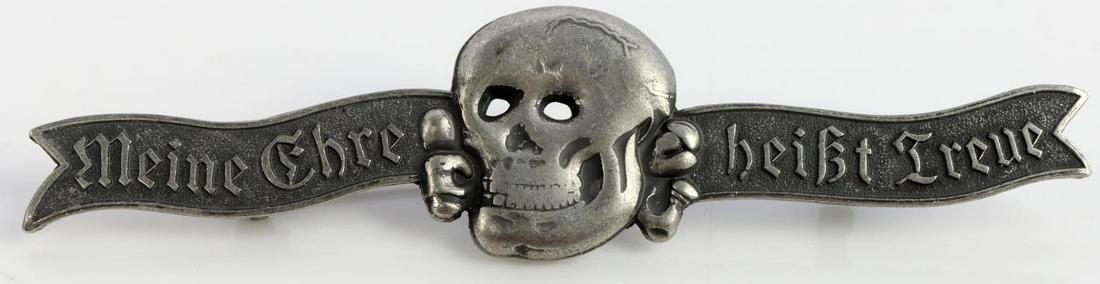 WWII GERMAN THIRD REICH WAFFEN SS DRESS BADGE: German WWII Waffen SS Skull Formal Dress Breast Badge. Measures 4 1/8 X 1 inches. The front shows a jawed skull and cross bones in the center. It reads ‘Meine Ehre heist Treue’ (My Honor is Loyalt