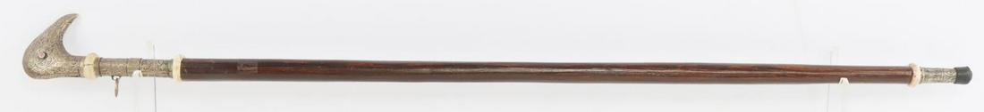 ANTIQUE 19TH CENTURY SWORD CANE WALKING STICK: Bird head shaped handle with repousse pattern. Wooden shaft with handle measures 35 5/8. Weapon measures 18 3/8 inches. Very good condition. This lot has a reserve.