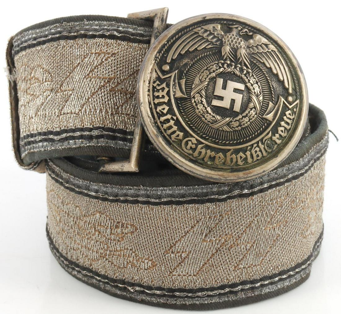 WWII GERMAN SS OFFICER BROCADE BELT & BUCKLE: Non-fluorescing. Alternating SS runes and oak leaves. Buckle marked RZM SS 93/38. Leather portion on belt stamped SS. Appears to have a name written on belt. Belt measures 34 inches long. Very good co