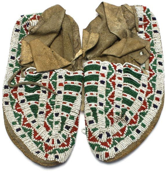 ANTIQUE PAIR OF BEADED NATIVE AMERICAN MOCCASINS: Antique 1900's beaded leather lazy stitch moccasins, possibly from the Cheyenne tribe. Measures 9 inches long. Wear from use, and some loose bead strands. Needs reshaping.