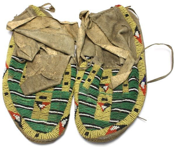 PAIR OF ANTIQUE NATIVE AMERICAN MOCCASINS: Antique 1900's beaded leather lazy stitch moccasins, possibly from the Cheyenne tribe. Features triangle design. Measures 9.5 inches long. Wear from use, some loose bead strands, some missing beading.