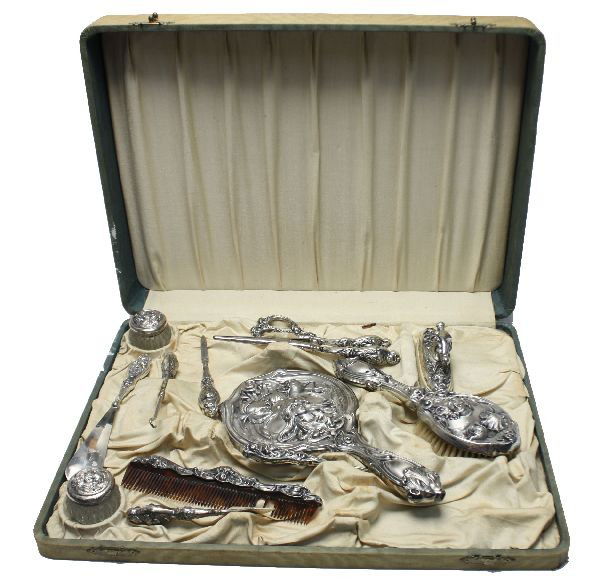 ART NOUVEAU SILVER PLATED 12 PIECE VANITY SET: Art Nouveau figural 12 piece silver plated vanity set including mirror, comb, two powder jars, hair brush, nail file, and more. Comes in original case, measures 13.5 by 18 by 3 inches. Comb missing se
