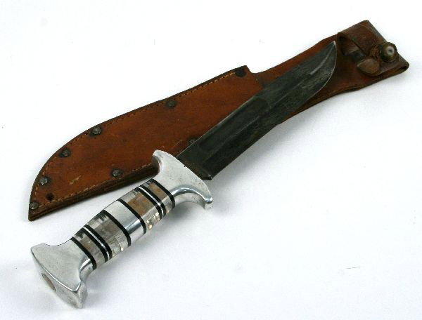 WWII CAMILLUS USN MK2 FIGHTING KNIFE: WWII Camillus USN MK2 fighting knife. With combat altered grip of lucite and chrome. Blade measures 7 inches over measures 12 inches. In very good condition. Original scabbard (snap torn).