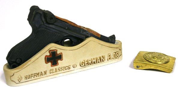 REPRO THIRD REICH ITEMS-BELT BUCKLE & GUN BOTTLE: Reproduction gold 2.5 by 2 inches "Gott Mit Uns" belt buckle in good condition. 8 by 4.5 inches porcelain Hoffman Classics model German P.08 Parabellum liquor bottle (contents removed).