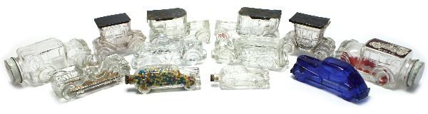 12 ANTIQUE CAR GLASS CANDY CONTAINERS: Eleven antique car glass candy containers and one fire truck. Many different styles cars and sizes. One blue glass car. Most have bottoms, corks, or caps. In good condition. Longest measuring around 5