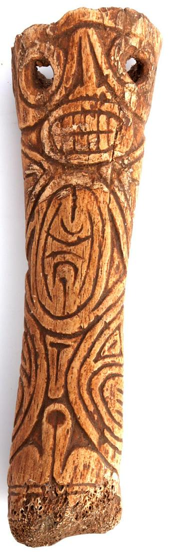 TAINO BONE CEMI FULL ENGRAVED ARTIFACT: Taino. Bone Cemi. Fully engraved front and back with an anthropic being on front and characterized zoomorph on back. The eyes are pierced. The complex symbolism is quite appealing. Length 3.5 “ Tain