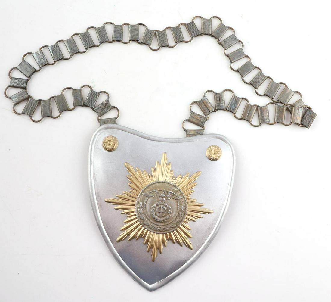 WWII NAZI GERMAN SA FLAG BEARER GORGET WITH CHAIN: A WWII Nazi German stamped brass construction heart shaped gorget, a cloth backing and complete with a nickel chain. Marked R.Z.M and M 3412 on backside. Gorget: 5 x 4 3/4 in. Chain L: 25 in. All meas
