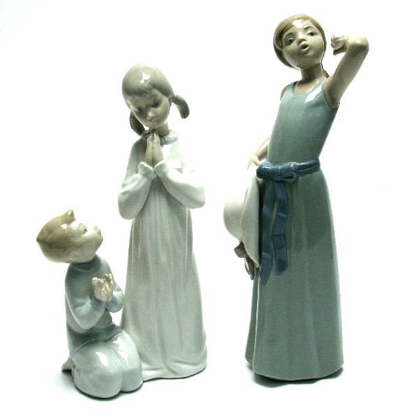 2 LLADRO PORCELAIN FIGURES: Two Lladro porcelain figures. Includes Girl and Boy Praying number 4779 and Curious Girl with Straw Hat number 5009. Features makers mark on bottom. Overall in very good condition.