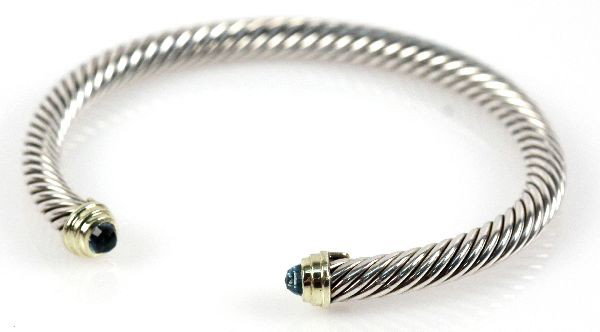 DAVID YURMAN STERLING SILVER TOPAZ CABLE BRACELET: David Yurman sterling silver twist cuff cable bracelet. Marked DY 925. Features blue topaz. Size: 6.5 inches Weight: 27.0 g Condition: Overall in excellent condition.