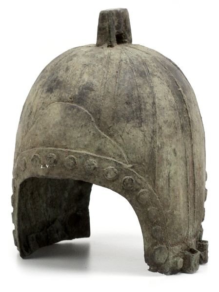 ANCIENT CHINESE WESTERN ZHOUS STYLE HELMET: Ancient Chinese Western Zhou style helmet. Measures 12 by 8 by 7 inches. Wear from age some cracks and minor holes, overall in very good museum quality condition.