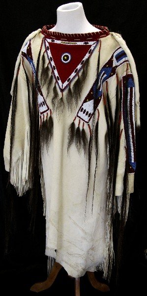 SIOUX BEADED WAR SHIRT MADE BY MICHAEL SPIRIT HAWK: Antique Sioux Indian beaded war shirt. Made by Michael Spirit Hawk ( one of the costume designers for Dances with Wolves). Made from buffalo skin, featuring arm fringe, geometrical beadwork in red, wh